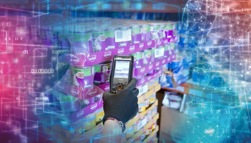 Ręka w rękawiczce skanuje puszki karmy dla kotów. To przykład, jak SSCC (Serial Shipping Container Code) usprawnia logistykę i śledzenie towarów w magazynie.