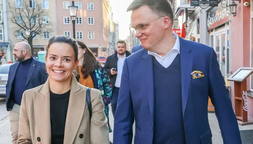 Aleksandra z uśmiechem idzie ulicą, obok niej jej mąż.