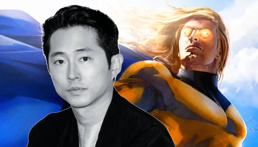 Steven Yeun, potentiel Sentry, pose devant une cape bleue et le héros aux yeux lumineux.