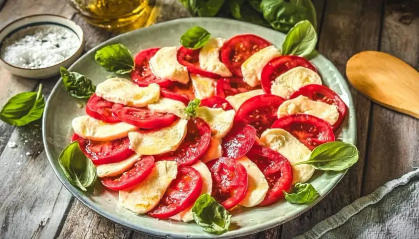 Frische Tomaten und Mozzarella, arrangiert als klassische Caprese. Ein einfaches, aber köstliches Gericht, das die Aromen Italiens feiert.
