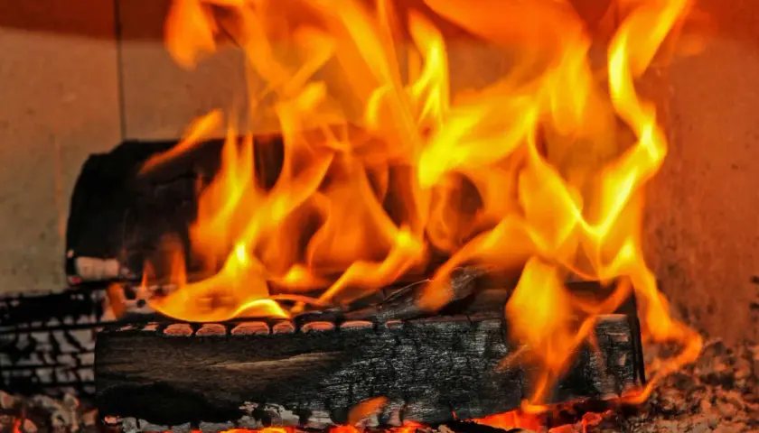 Glühende Kohlen und Flammen zeigen den hohen **erle brennwert** eines Kaminfeuers.