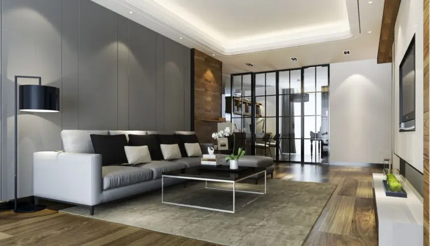 Nowoczesny salon z szarym sufitem, który stanowi świetny pomysł na sufit w salonie. Wygodna kanapa, szklane drzwi i drewniane akcenty tworzą elegancką przestrzeń.