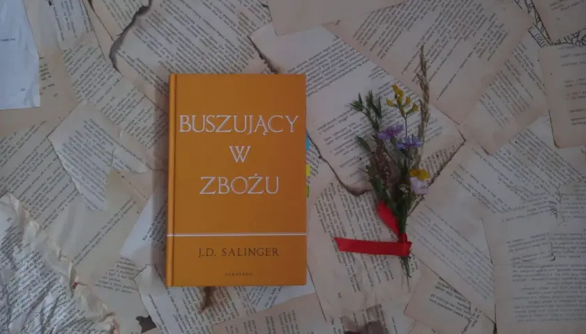 Buszujący w zbożu J.D. Salingera, opowieść o dojrzewaniu i poszukiwaniu autentyczności, leży na pożółkłych kartkach.