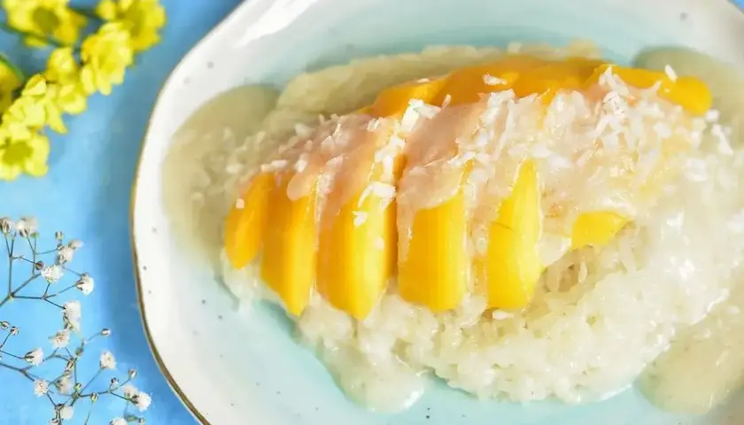 Słodki ryż kleisty z kawałkami mango i wiórkami kokosowymi, polany kremowym sosem. Pyszny deser mango sticky rice.
