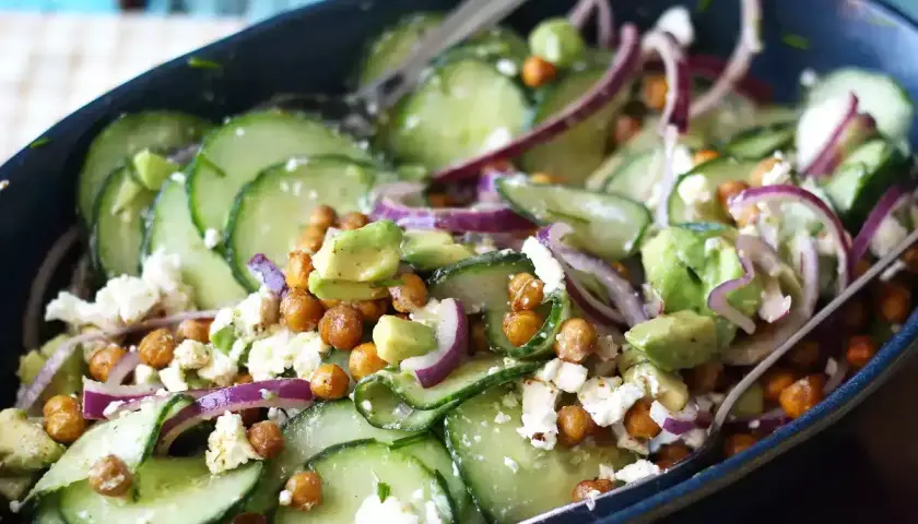 Deliziosa insalata di cetrioli con ceci croccanti, avocado cremoso, cipolla rossa e formaggio feta sbriciolato.