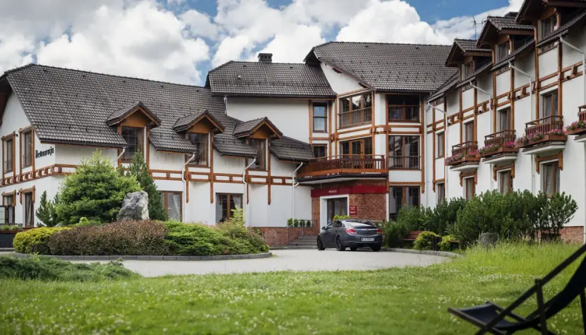 Elegancki hotel premium Wisła z drewnianymi elementami architektonicznymi i zadbanym ogrodem.