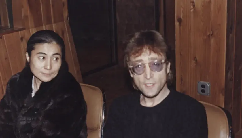 John Lennon i Yoko Ono siedzą w studiu. Yoko w czarnym futrze, John w okularach.