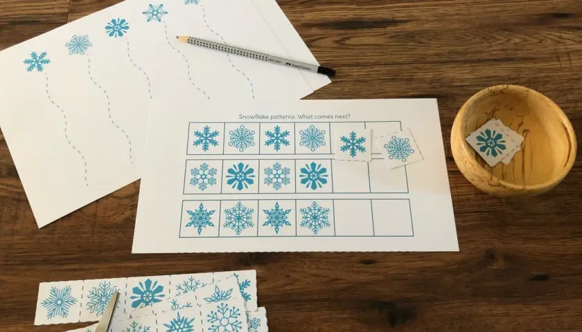 Actividades invierno Montessori: hojas con copos de nieve para recortar y completar patrones. Tijeras y lápiz listos.