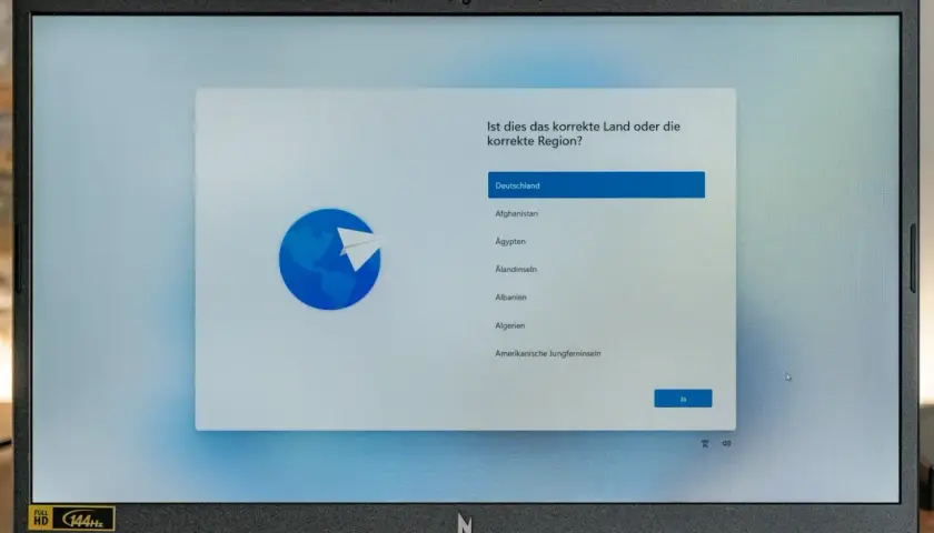 Ein Laptop zeigt die Windows 11 Einrichtung mit der Länderauswahl. Hier kann man Windows 11 ohne Microsoft Konto einrichten, indem man Deutschland wählt.