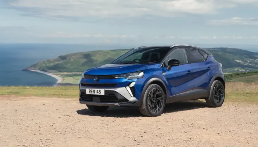 Niebieski Renault Captur na tle malowniczego wybrzeża. Idealny wybór na wakacyjne podróże, dostępny w atrakcyjnym **Renault w leasingu**.