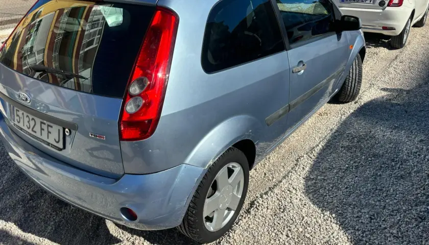 Ford Fiesta 1.4 TDCI con algunos problemas visibles, aparcado sobre grava.