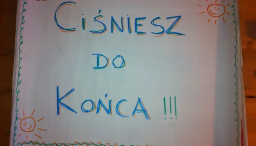 Hasła dopingujące biegaczy: "Ciśniesz do końca !!!" z uśmiechniętymi słoneczkami po bokach.