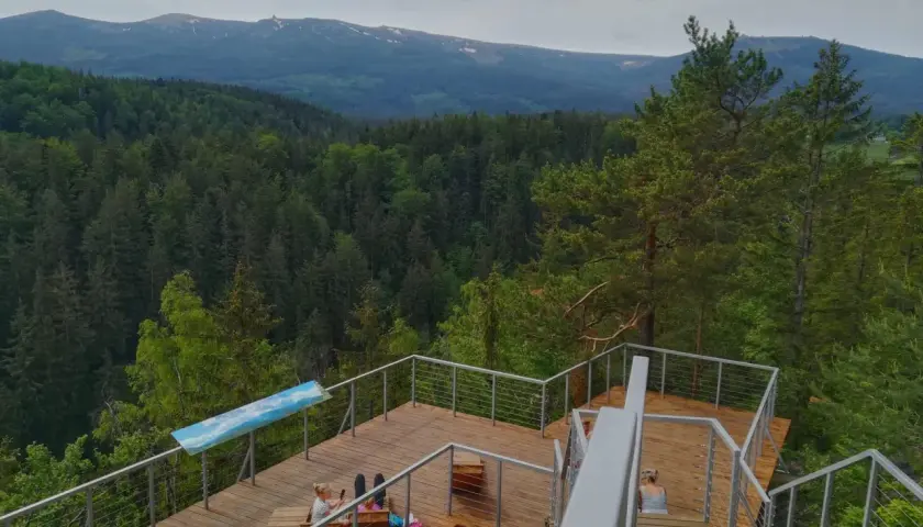 Drewniany taras z widokiem na góry i las. Idealne miejsce na relaks w Karpaczu, restauracja z widokiem zachwyca.