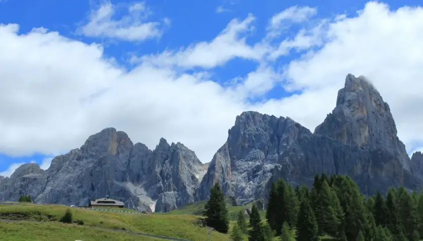 Majestuosas montañas de los Picos de Europa, un paisaje ideal para recorrer con tu camper. Nubes blancas adornan el cielo azul.