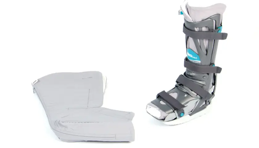 Ein VACU-PED Schuh, wie fest er ist, und sein gepolsterter Innenschuh auf weißem Hintergrund.
