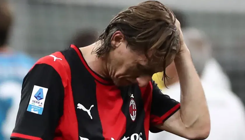 Piłkarz Milanu z opuszczoną głową, zmartwiony po przegranym meczu w Serie A. Tabela liga włoska nie wygląda dziś dla niego dobrze.