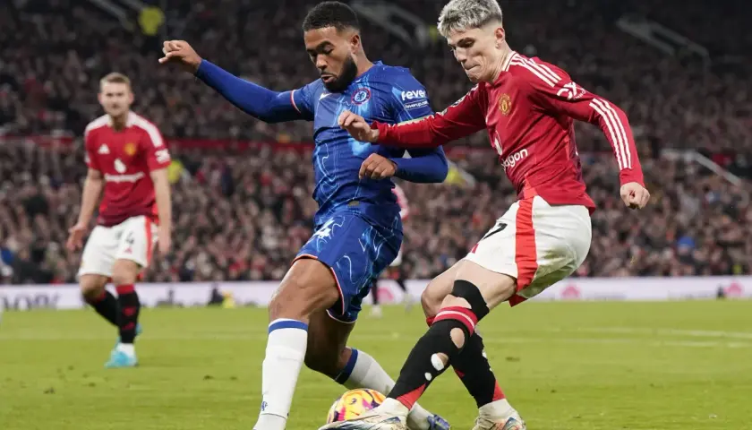 Piłkarze w akcji, jeden w niebieskiej koszulce Chelsea, drugi w czerwonej koszulce Manchesteru United. Mecze tych klubów to często starcia najbogatszych klubów piłkarskich.