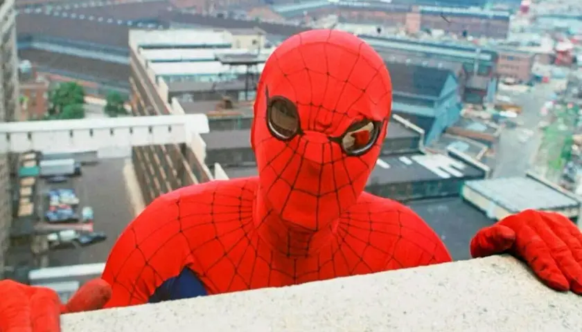 Le premier Spiderman acteur, Nicholas Hammond, se penche au-dessus d'un mur, regardant la ville.