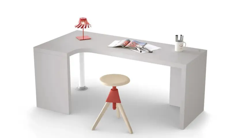 Scrivania in cartongesso angolare con sgabello, lampada rossa e tazza sorridente.
