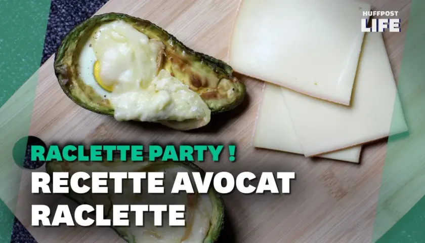 Avocat farci d'un œuf et de fromage fondu, une recette de raclette sans pomme de terre, avec des tranches de fromage à côté.