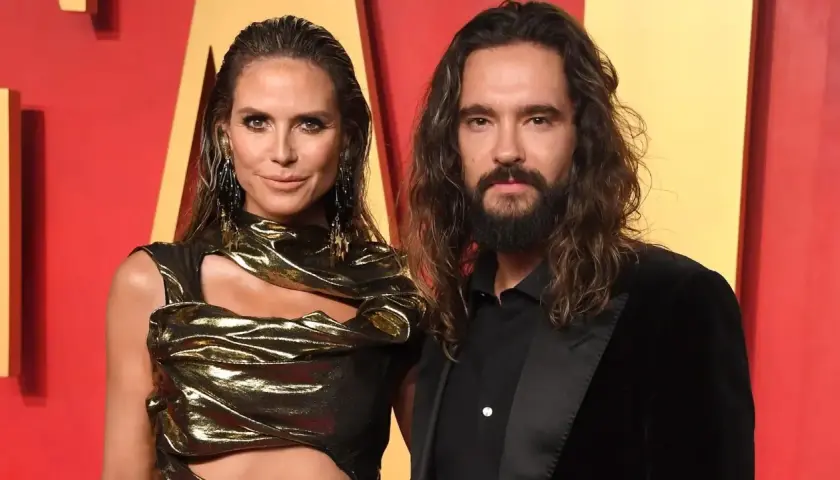 Heidi Klum i Tom Kaulitz na czerwonym dywanie, ona w złotej kreacji, on w czarnym garniturze.