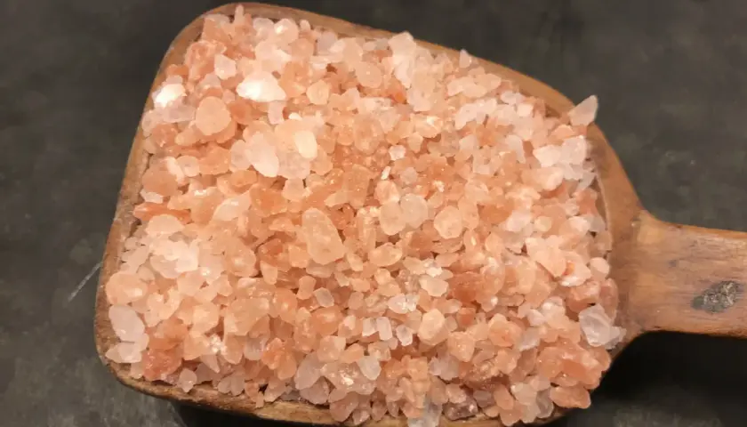 En träskopa fylld med rosa himalayasalt. Många anser att detta naturliga salt är nyttigt och ger en fin färg till maten.