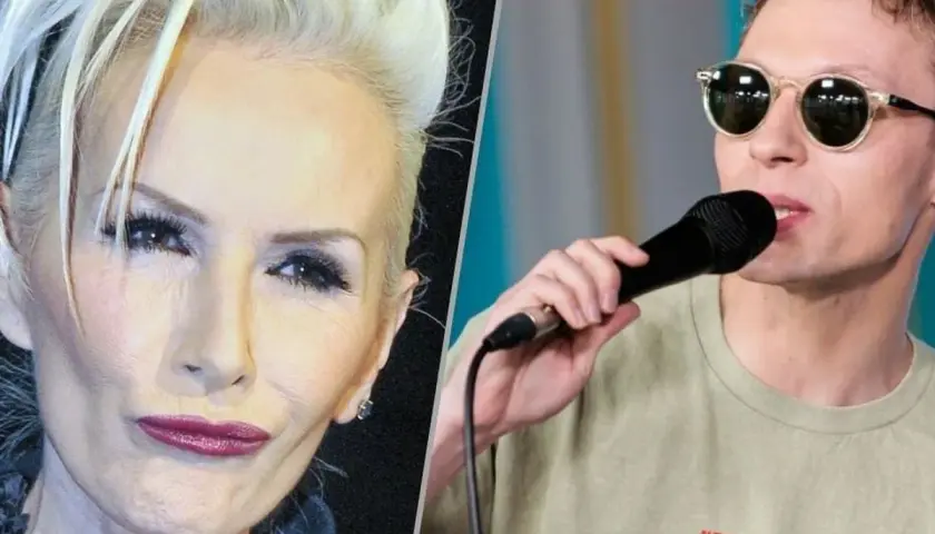 Kobieta z blond włosami i mężczyzna w okularach śpiewają. Tekst piosenki "czekam na wiatr co rozgoni" pasuje do tej sceny.