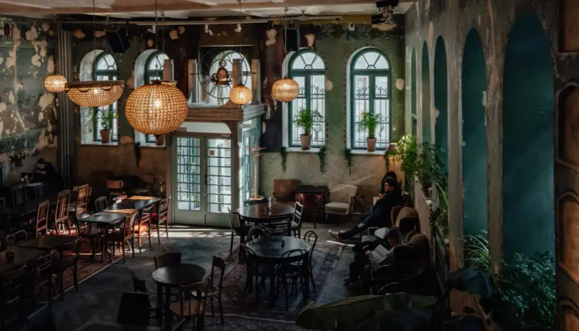Wnętrze pełne uroku, z dużymi, okrągłymi lampami i zielonymi akcentami. Idealne miejsce na relaks w jednej z klimatycznych restauracji w Krakowie.