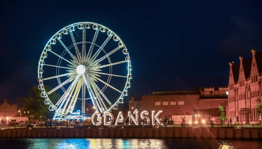 Nocą w Gdańsku: podświetlany diabelski młyn i napis "GDAŃSK" to nietypowe atrakcje, które zachwycają nad Motławą.