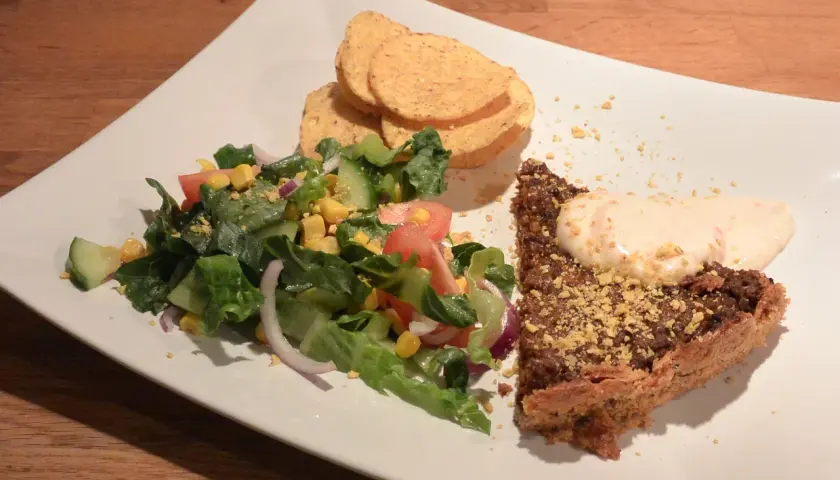 En bit tacopaj med en fräsch sallad till, toppad med krutonger och en klick krämig sås.