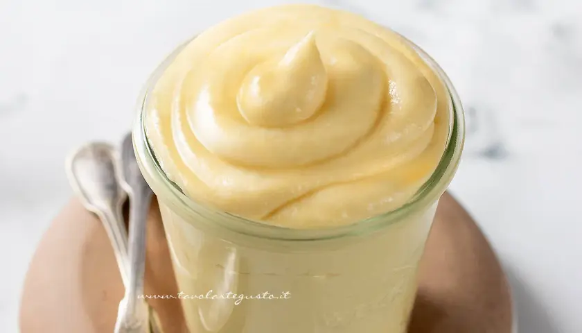 Deliziosa crema chiboust in un vasetto, pronta per essere gustata con due cucchiaini d'argento.