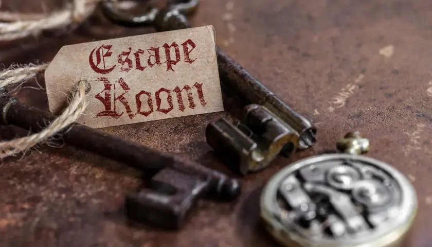 Stare klucze i zegarek kieszonkowy, a na nich etykieta z napisem "Escape Room". To zapowiedź najlepszego escape roomu w Polsce!