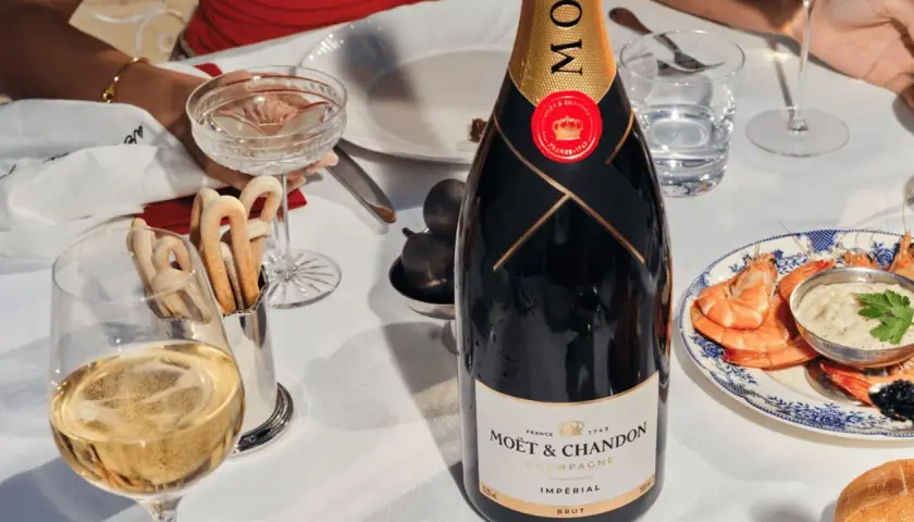 Elegante Tafel mit Moët & Chandon Champagner, Garnelen und Brot. Die Herkunft des Champagners ist unverkennbar.
