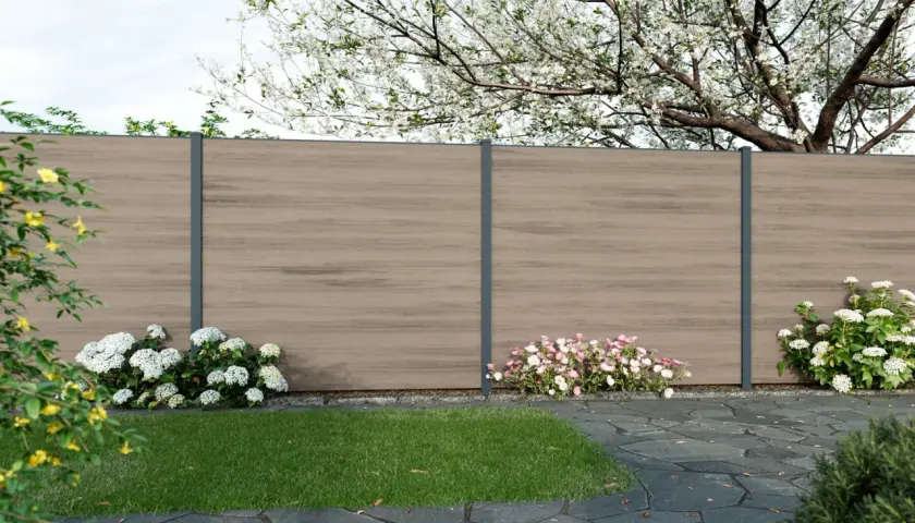 Moderne gartenzaun ideen bilder: Ein Sichtschutzzaun aus Holzoptik mit anthrazitfarbenen Pfosten, umgeben von blühenden Sträuchern und einem gepflegten Rasen.