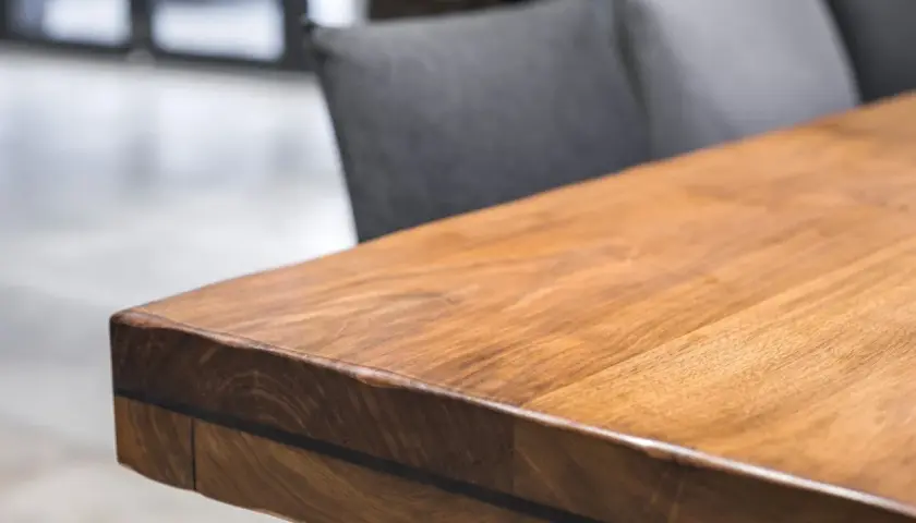 A close-up of a beautiful acacia wood table, showcasing its rich grain and warm tones. Is acacia wood good? This table suggests yes!