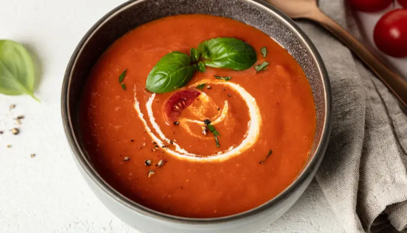 Eine cremige, vegane Tomatensuppe mit Basilikum und einem Klecks Sahne. Perfekt für kalte Tage.