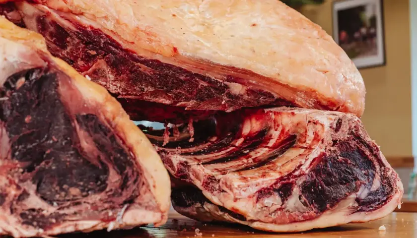 Gros morceaux de bœuf, prêts pour le dry aging, révélant une viande rouge foncée et une belle couche de gras.