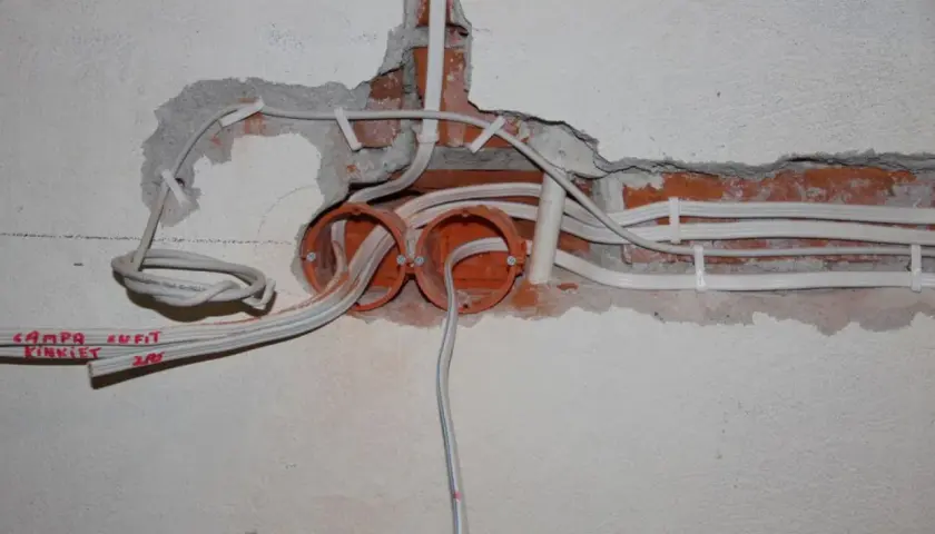 Widoczne przewody i puszki elektryczne, część instalacji elektrycznej w domu.