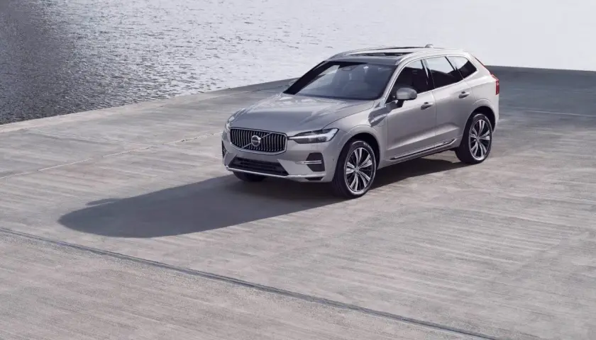 Srebrne Volvo XC60 na betonowym placu przy wodzie. Zwróć uwagę na rozmiar opon, idealnie dopasowany do SUV-a.