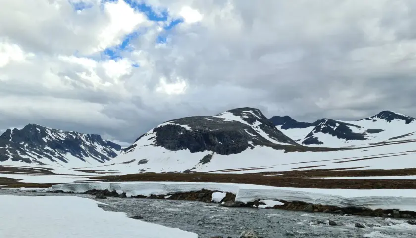 Snöklädda berg och en forsande älv i Jämtland. En dröm att bestiga Sylarna i detta landskap.