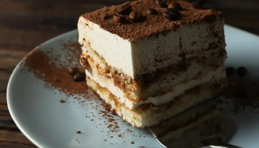 Pyszne tiramisu włoskie, warstwowe ciasto z kremem i kakao, ozdobione ziarnami kawy.
