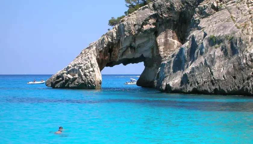 Arco naturale su mare cristallino, un paradiso tra i posti più belli del mondo mare. Barche e sub esplorano le acque turchesi.
