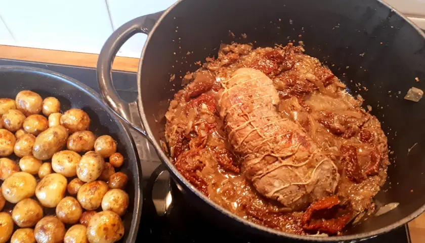 Un quasi de veau mijote dans une sauce aux tomates séchées et oignons, accompagné de pommes de terre rôties.
