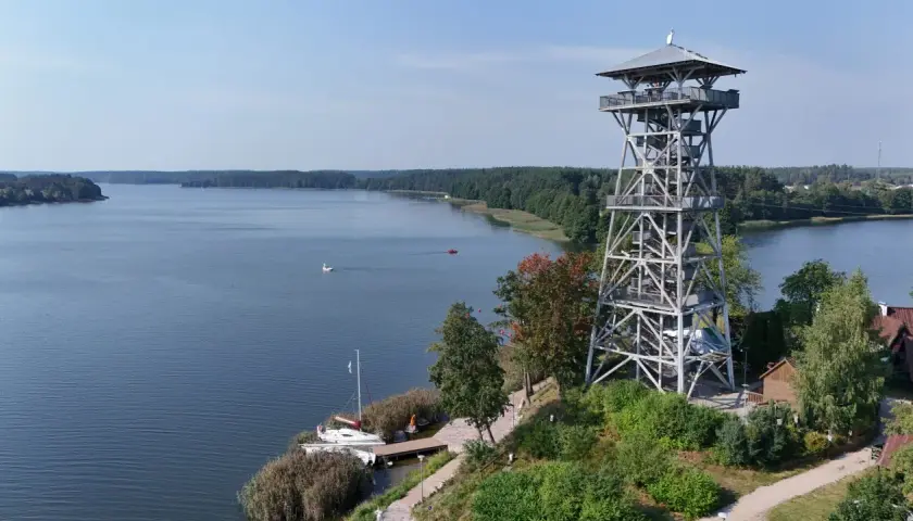 Wieża widokowa we Wdzydzach góruje nad jeziorem, oferując malowniczy widok na wodę i las.