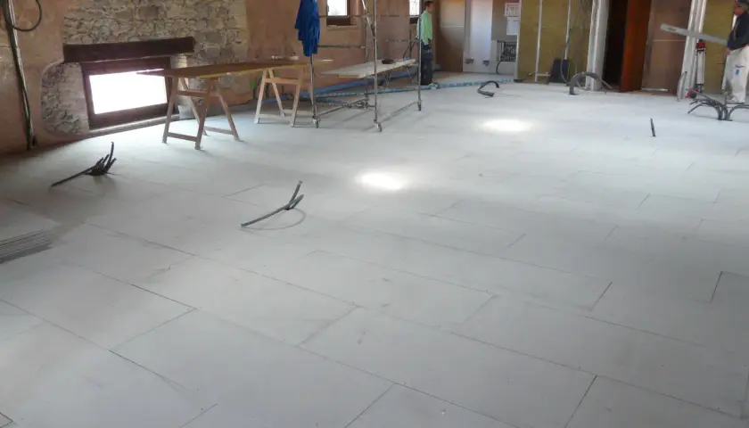 Pannelli per insonorizzare il pavimento in fase di posa, con tubi e attrezzature da cantiere.