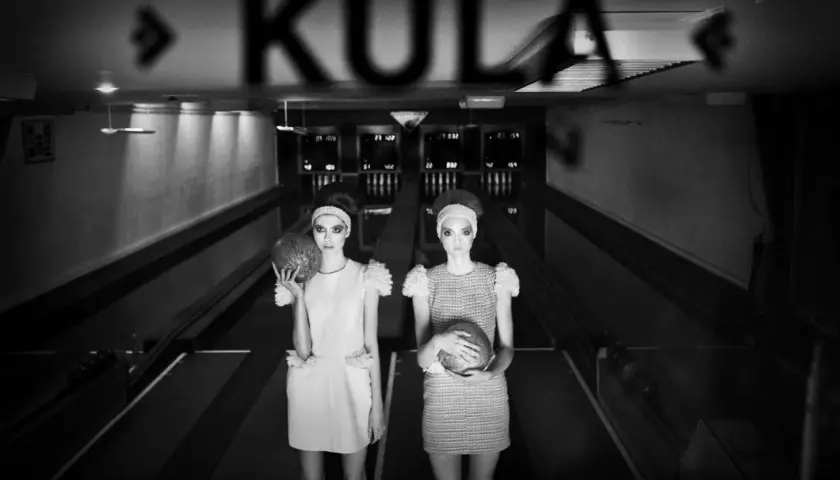 Dwie modelki w retro stylizacjach z kulami do kręgli na torze. Idealne, ładne tło do zdjęć w klimacie vintage.
