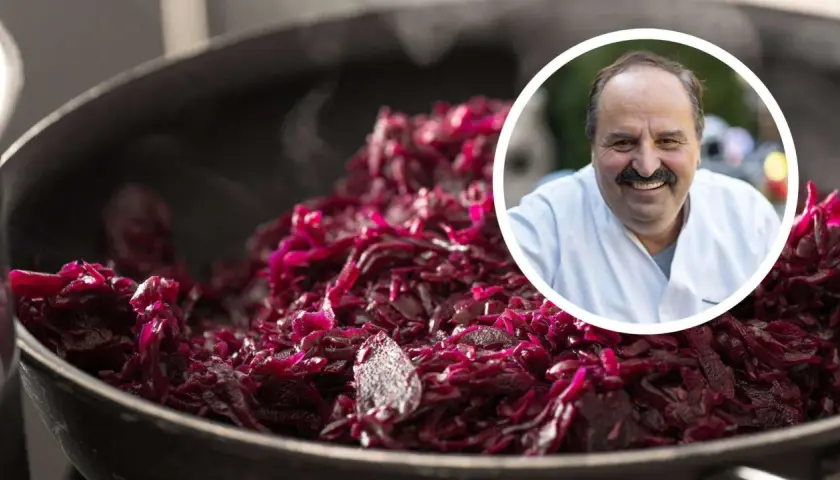 Ein Koch lächelt, während er dampfendes Blaukraut verfeinert.