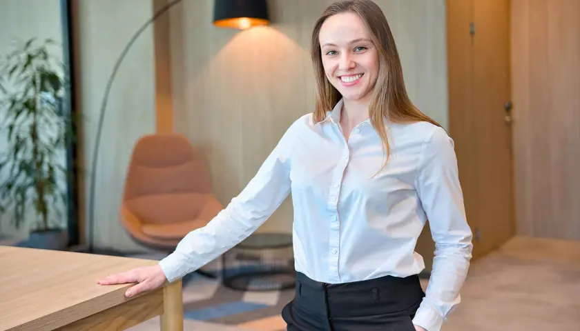 Uśmiechnięta agentka nieruchomości, zastanawiająca się, ile zarabia agent nieruchomości.