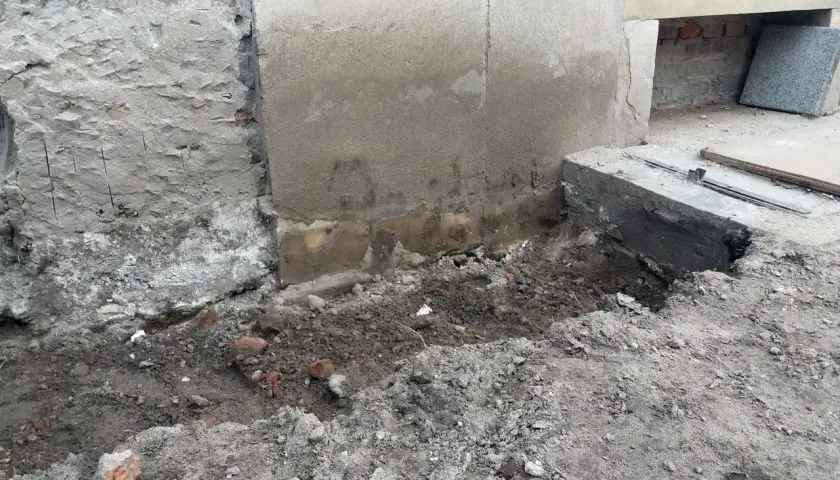 Prace przy podbijaniu fundamentów. Widoczny wykop i fragmenty muru.