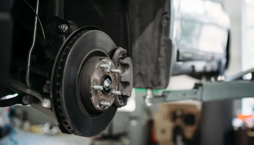 Nahaufnahme der Bremsscheibe und des Bremssattels eines PKW, bereit für Wartung oder Reparatur.